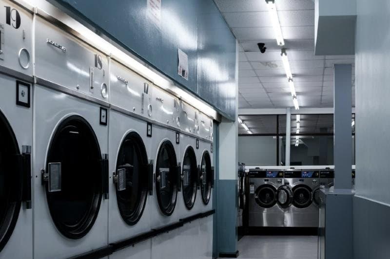 Inside a clean, bright laundry with rows of washing machines